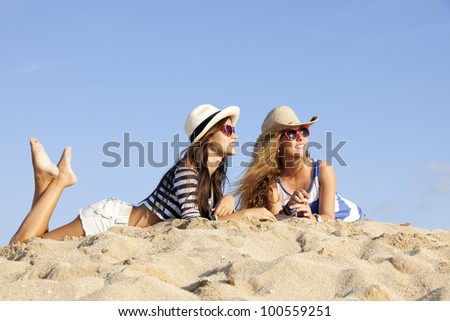 girls laying in sand on summer vacation