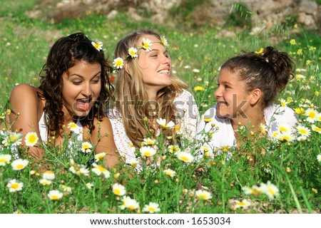 3 friends relaxing in a meadow of flowers