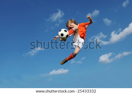 (MOTION BLUR ON FEET AND BALL) young boy, football player doing amazing kick