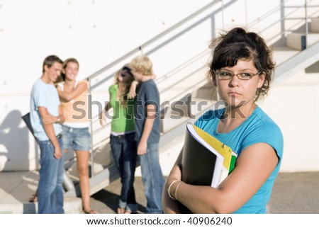 outcast sad girl at university with group of friends behind