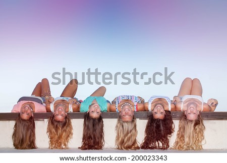 happy teens with long healthy hair laying upside down.