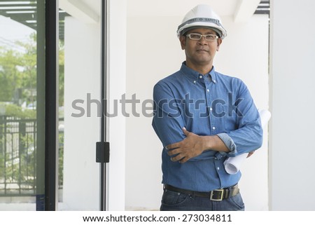 Portrait of  Asian male contractor engineer with hard hat holding paper work