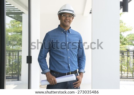 Portrait of  Asian male contractor engineer with hard hat holding paper work