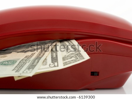 Photo of a telephone and dollars over a white background