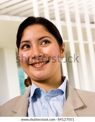 Smiling Asian Woman Wearing A Blue Blouse, Standing Outside Her Apartment