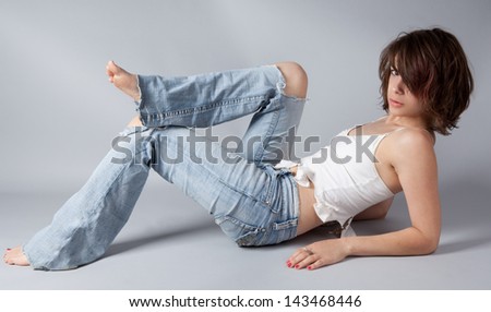 Sexy Model Posing in Ripped Jeans and a Ripped Tank Top