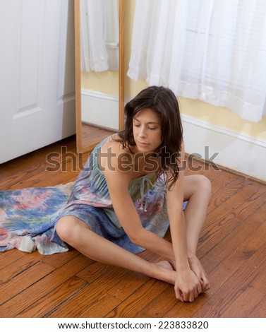 Young Woman in Tie Dye Dress Sitting on Floor