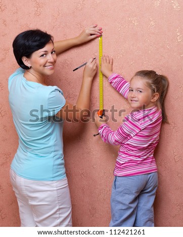 Young woman with her daughter doing home repair