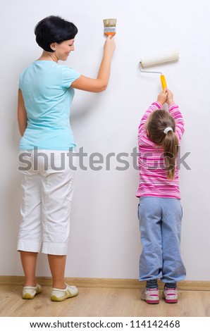 Young smiling woman and little girl with painting tools