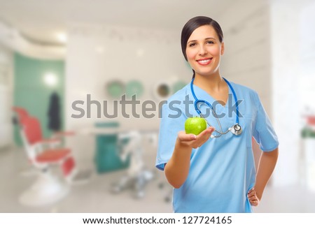 Young doctor with green apple on medical office