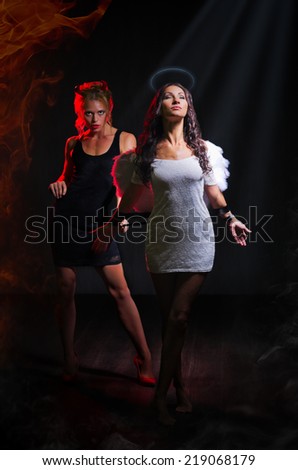 Angel and devil on dark background