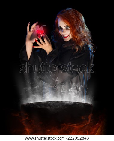 Young witch with red potion and cauldron isolated