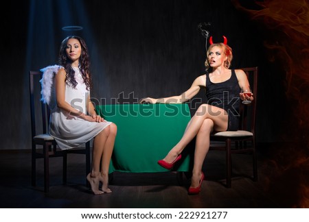 Angel and devil with cigar on dark background