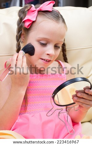 Little girl puts makeup on sofa