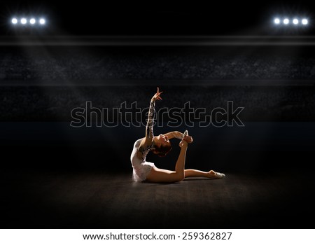 Girl engaged art gymnastics at sports hall