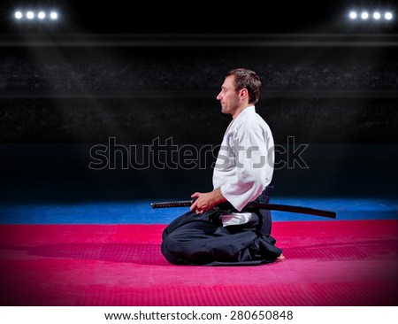 Martial arts fighter with sword at sports hall