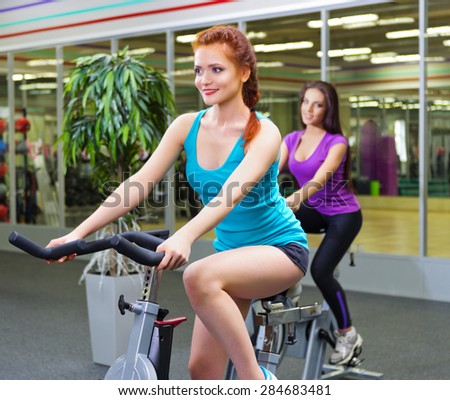 Two young sporty women at fitness club