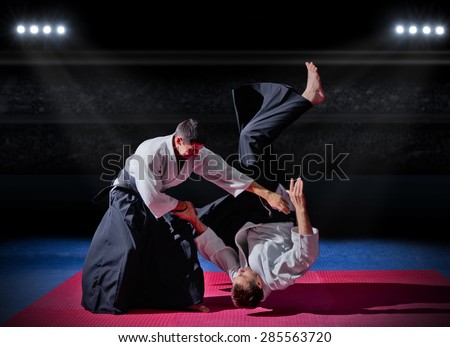 Fight between two martial arts fighters at sports hall