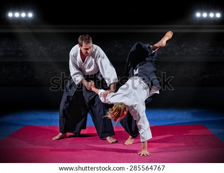 Fight between two martial arts fighters at sports hall