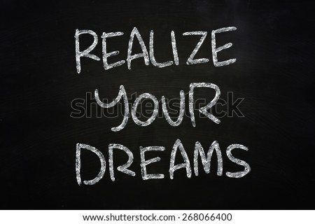 Motivational concept the words Realize Your Dreams written with chalk on blackboard