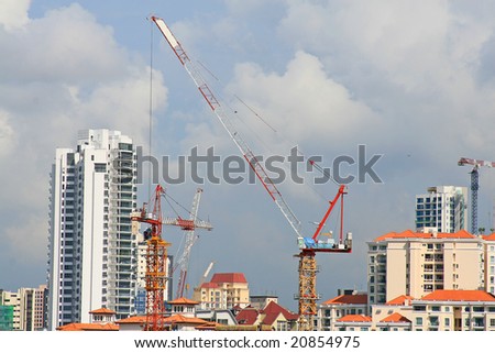singapore skyline with construction cranes under cloudy sky. room for text.