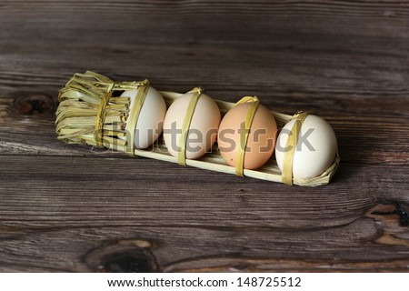 eggs packed in straw over brown background
