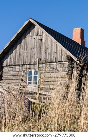 Vintage wooden country house and hedge, reed on front