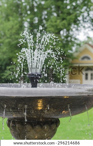 Old stone fountain closeup with dripping water and blurred background