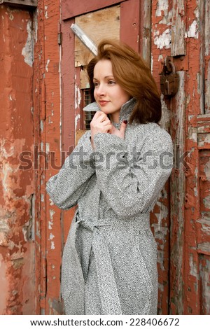 Beautiful red-haired woman standing near the closed door.