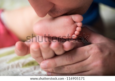 Father kissing foot sleeping child