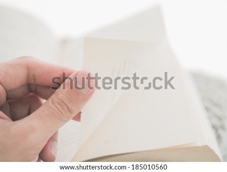 Person turning the pages of a book up close