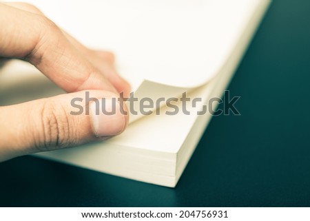 Person turning the pages of a book up close
