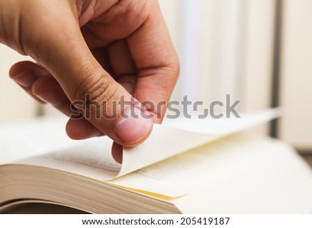 Person turning the page of a book up close