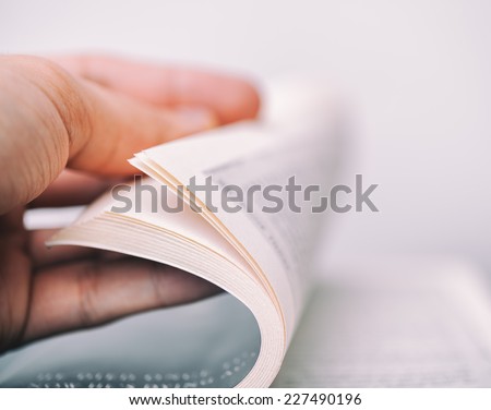 Person turning the pages of a book