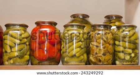 Jars of pickled vegetables tomatoes, mushrooms, cucumbers on shelf
