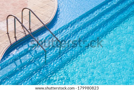 Curved side of a swimming pool with stairs.
