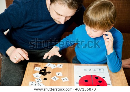 Dad teaches the child to count. Homework.