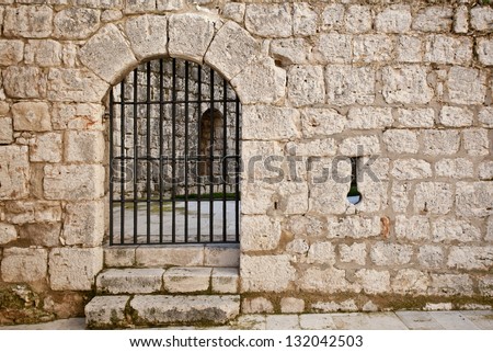 Old castle gate in a stone wall. Simancas Castle, Valladolid, Spain.