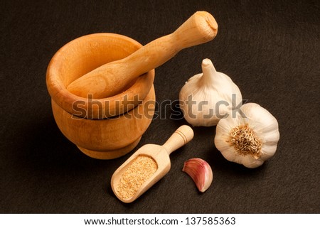 Still life of garlic bulb, mortar and crushed garlic