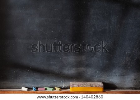 Blank blackboard with colored chalks and eraser. Horizontal composition and with Light and Shadows Effect
