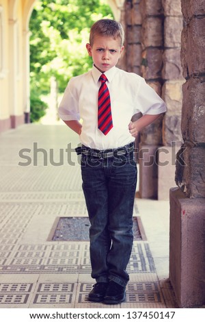Angry looking little boy in formal outfit