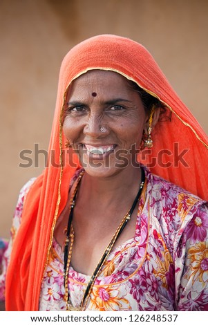 JAISALMER, INDIA - AUGUST 12: Indian woman on Thar desert on August 12, 2011 in Jaisalmer, India. About 40% of the population of Rajasthan live off the agriculture and animal husbandry in Thar desert