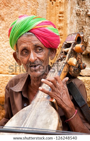 JAISALMER, INDIA - AUGUST 12 : Unidentified musician playing Sitar on street on August 12, 2011 in Jaisalmer, India. The Sitar is a plucked stringed instrument widely used in Indian classical music.