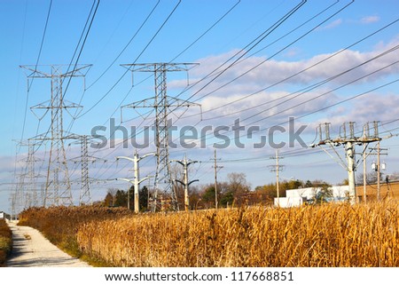 Electric power towers on a wild ground
