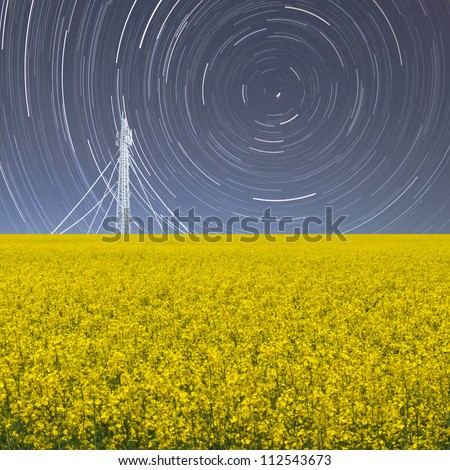 New visions, a conceptual image of a night exposure with startrail and a yellow field of flowers