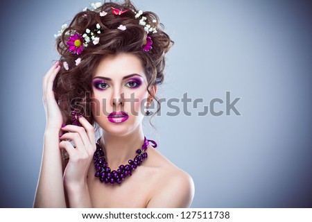 Young beautiful woman with flowers in her hair and bright artistic makeup