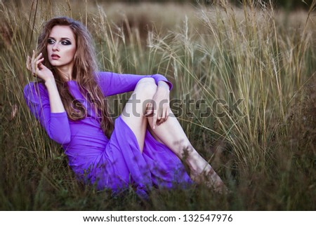 Young woman outdoors fashion portrait. Violet dress