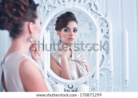 Fashion Portrait Of Young Beautiful Woman Looking In Antique Mirror, Bright Makeup And Jewelery