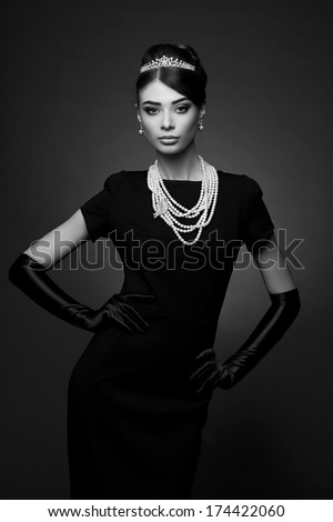 high fashion portrait of elegant woman in black dress and gloves. Black and white shot