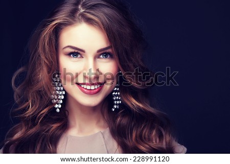 Beautiful model with curly  hair and fashion earrings